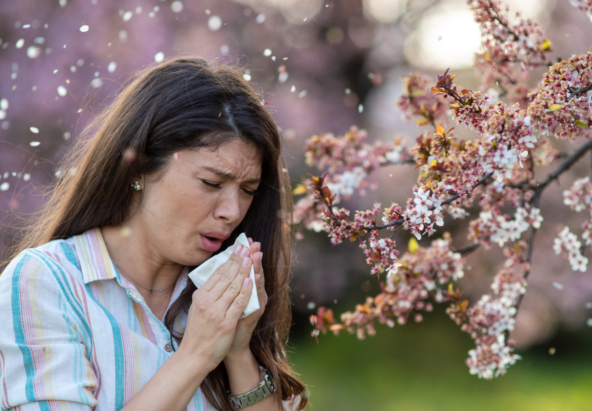 pyłek pyłki roślin alergia alergik Afraid,Young,Woman,Sneezing,In,Napkin,In,Front,Of,Blooming