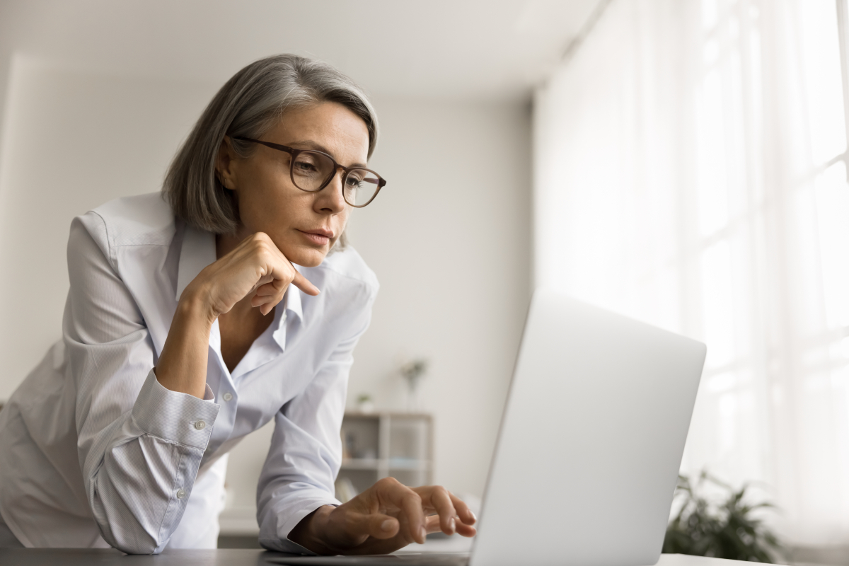 Thoughtful,Focused,Grey,Haired,Freelancer,Woman,In,Glasses,Looking,At
