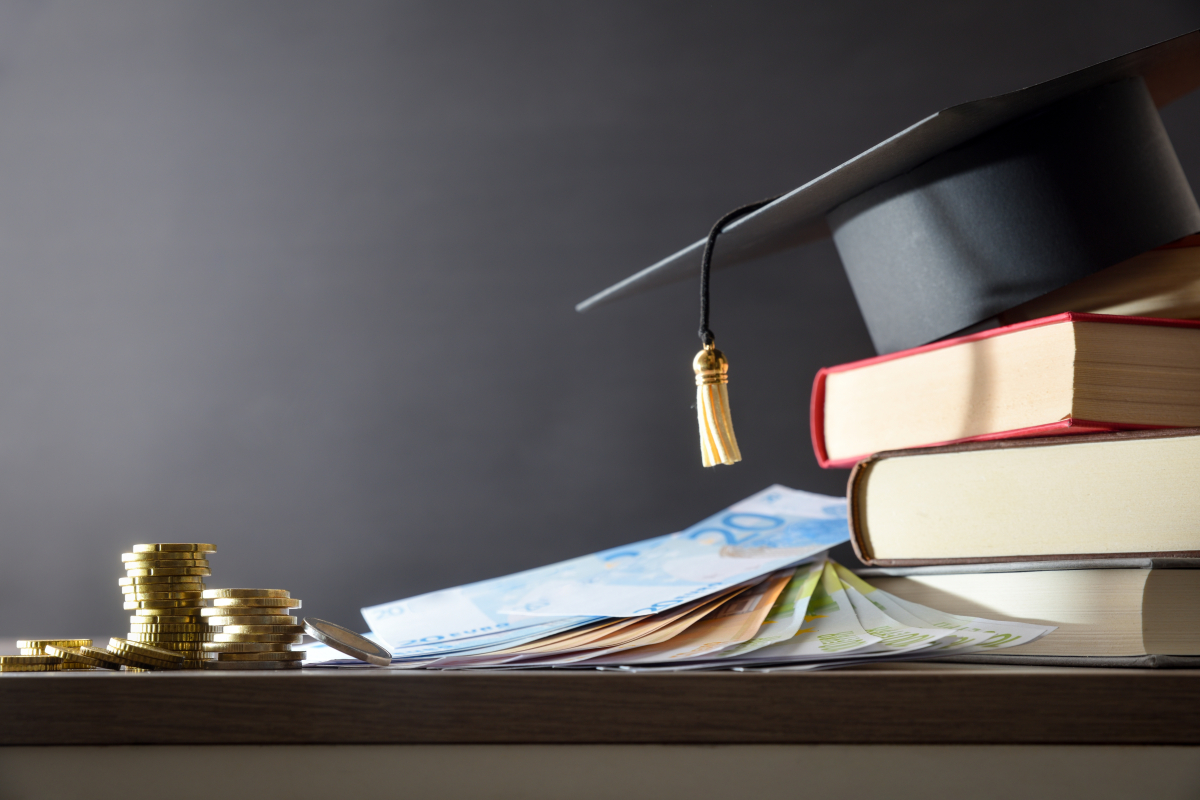 Education,Spending,Concept,Detail,With,Mortarboard,On,Stack,Of,Books