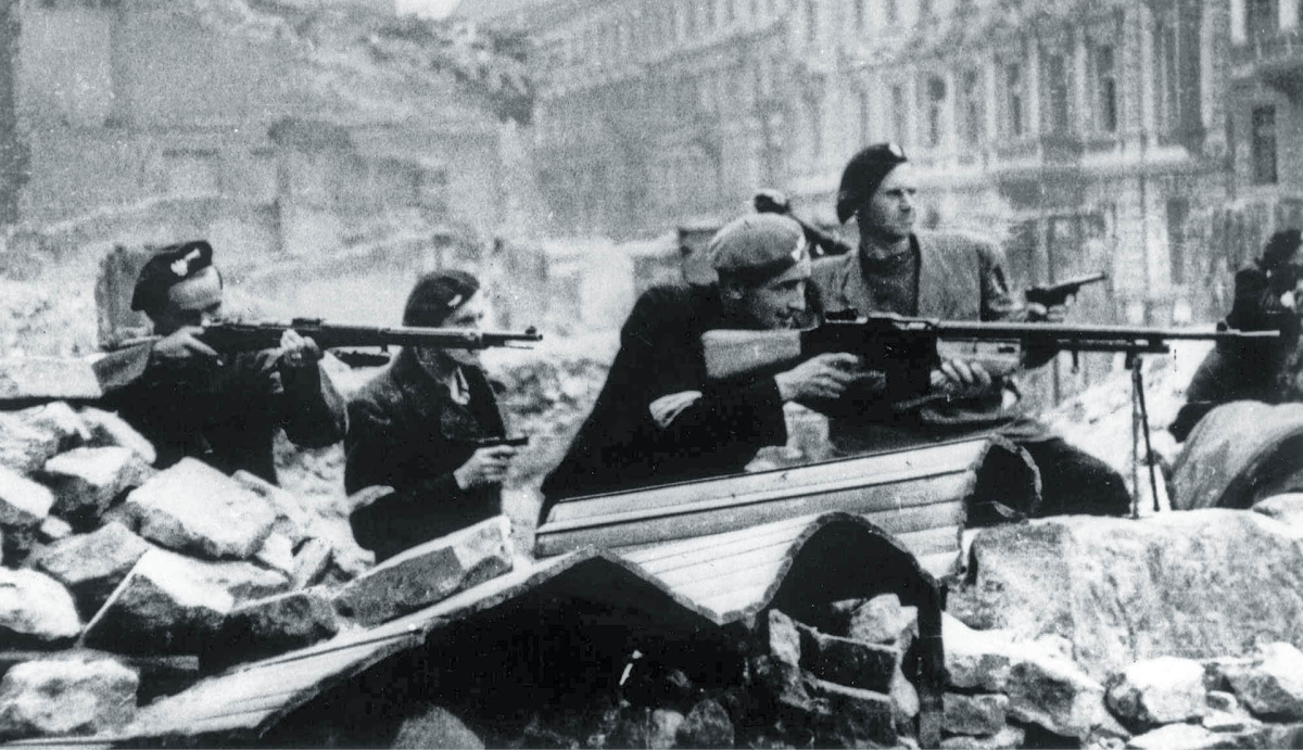 Powstańcy warszawscy walczą na barykadzie na skrzyżowaniu ul. Świętokrzyskiej z ul. Mazowiecką. Sierpień 1944 r.