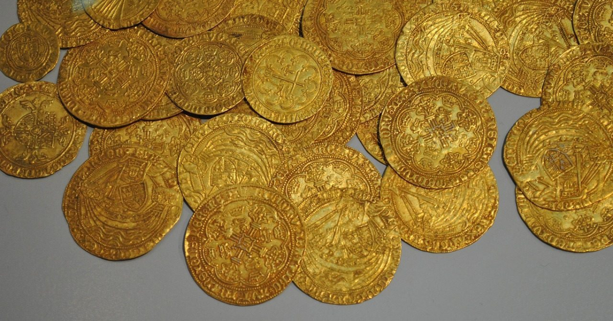 Historyczne złote monety bite ręcznie, ułożone na jasnym tle