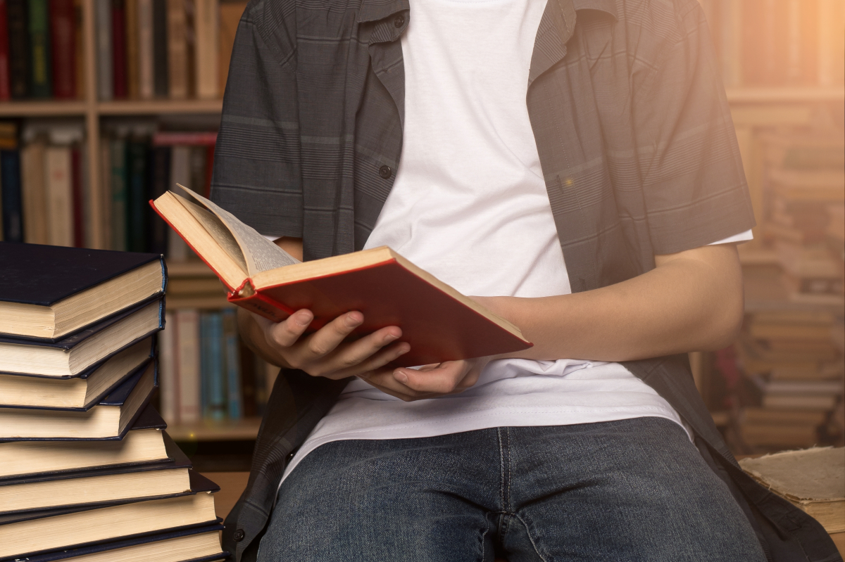 A,Young,Man,Reading,A,Red,Book,In,A,Cozy