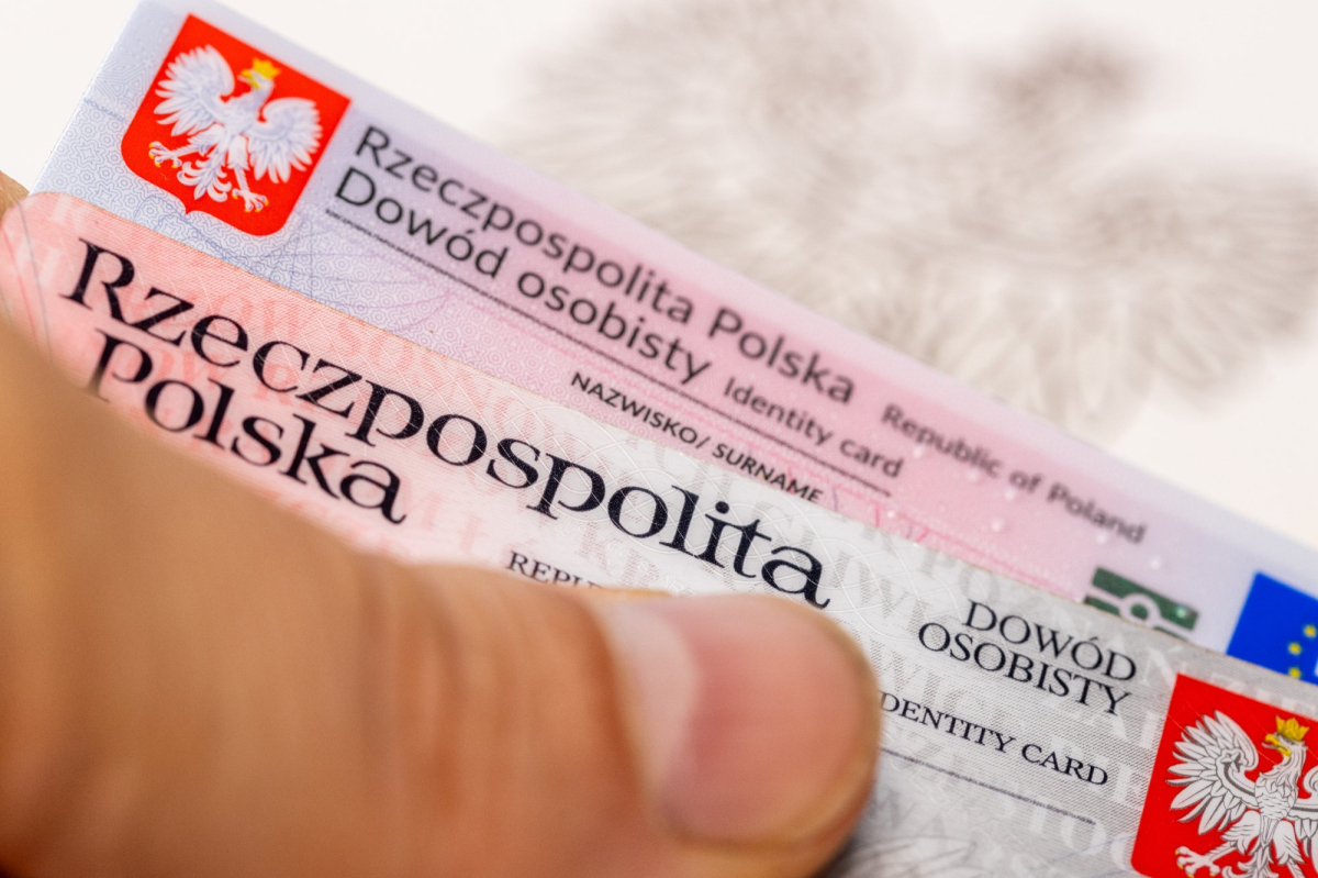 Mężczyzna trzyma w dłoni dowody osobiste