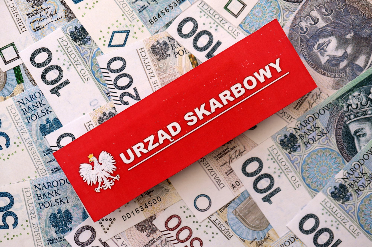 urząd skarbowy - napis na czerwonej tabliczce położonej na wielu banknotach 100 zł i 200 zł
