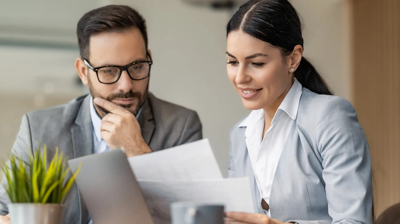 Pracodawca i pracownica przeglądają dokumenty w biurze. Rząd przygotował zmiany dotyczące sprawdzania dyplomów