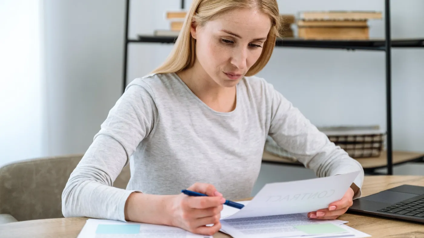 Focused,Woman,Sitting,In,Home,Office,,Checking,Documents,,Looking,Looking