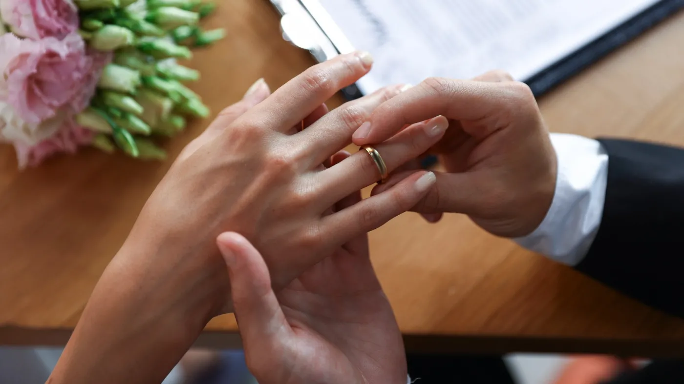 Man,Putting,Engagement,Ring,On,His,Girlfriend's,Finger,At,Wooden