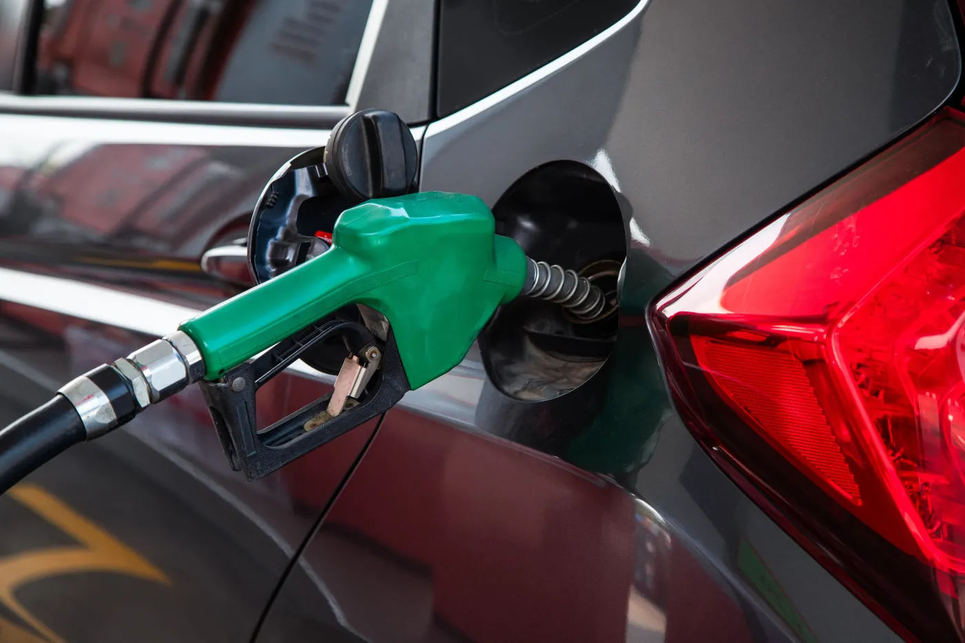 Close,Up,Of,A,Green,Fuel,Nozzle,Refueling,A,Dark