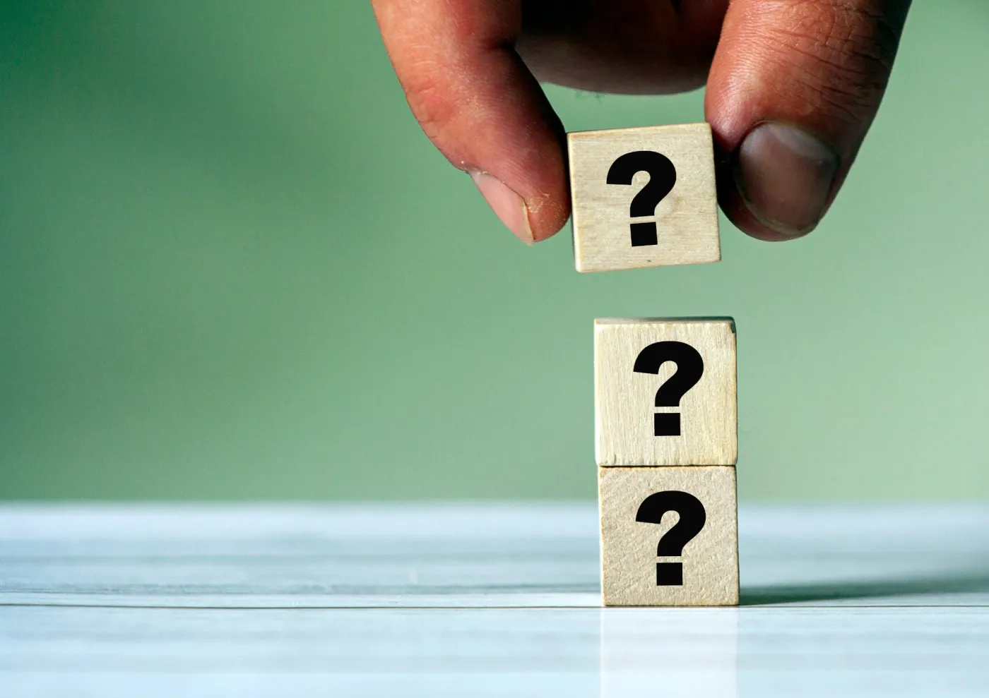 Three,Question,Mark,Sign,On,Wooden,Block.,Stack,Of,Question