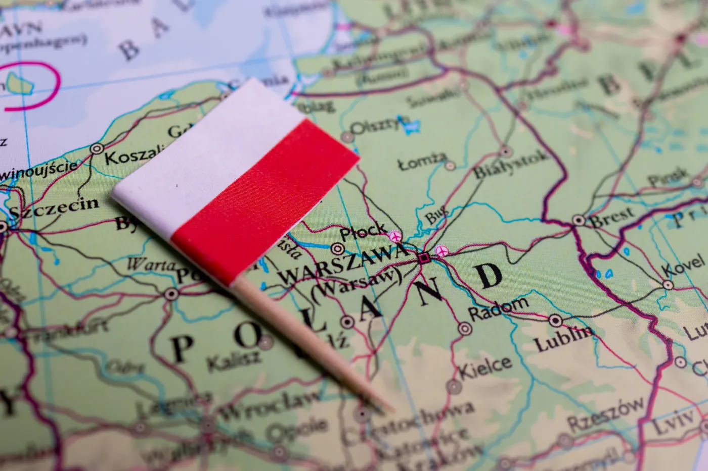 Fizyczna mapa Polski, na której leży białoczerwona flaga.
