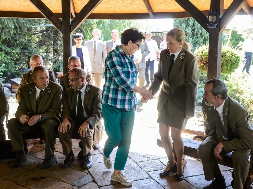 Ewa Kopacz u leśników w stylizacji "dziewczyna farmera" i w bardzo drogich trampkach