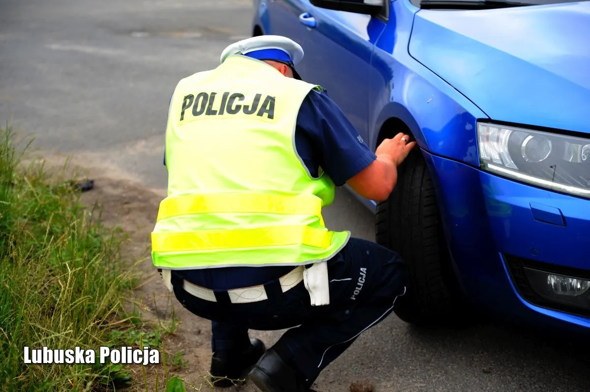 Policjant kontroluje stan opon