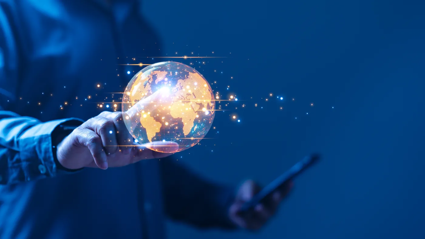 A,Person,Is,Holding,A,Cell,Phone,And,A,Globe