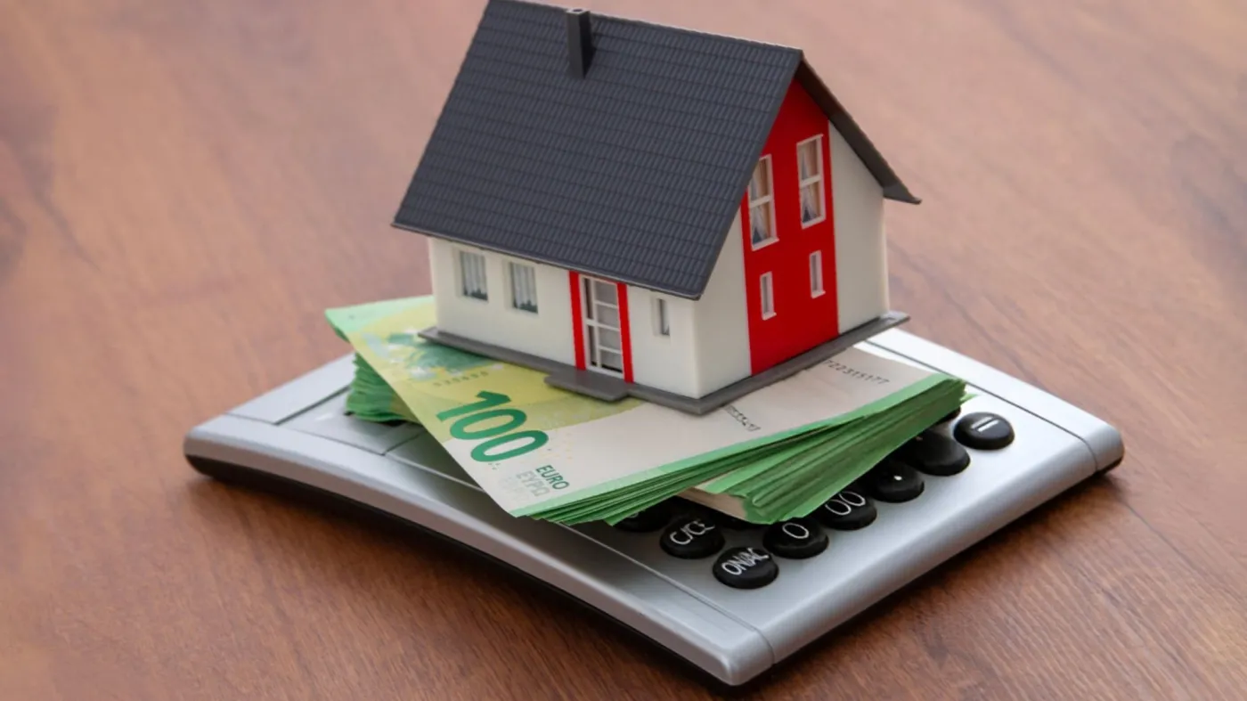 Miniature,House,On,Euro,Banknotes,And,A,Calculator,Â€“,Concept