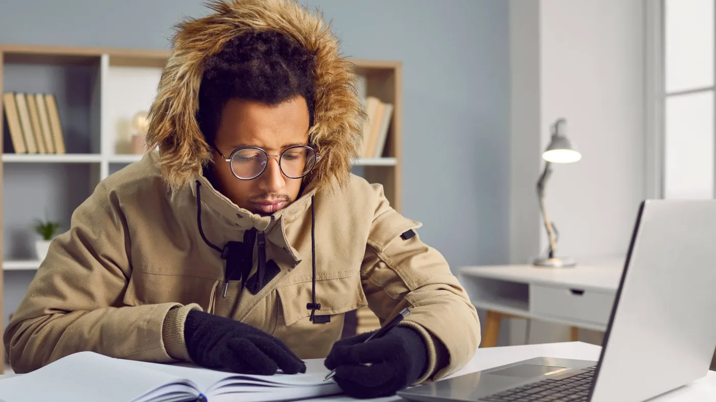 Freezing,African,American,Man,In,Outerwear,Working,At,Laptop,In