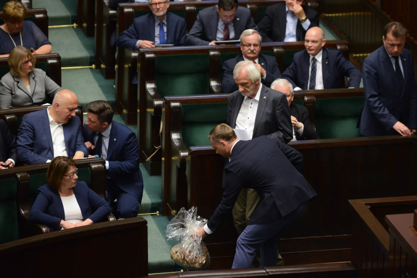 Poseł PO Sławomir Nitras (P) z workiem trocin, który wręczył politykom PiS w Sejmie
