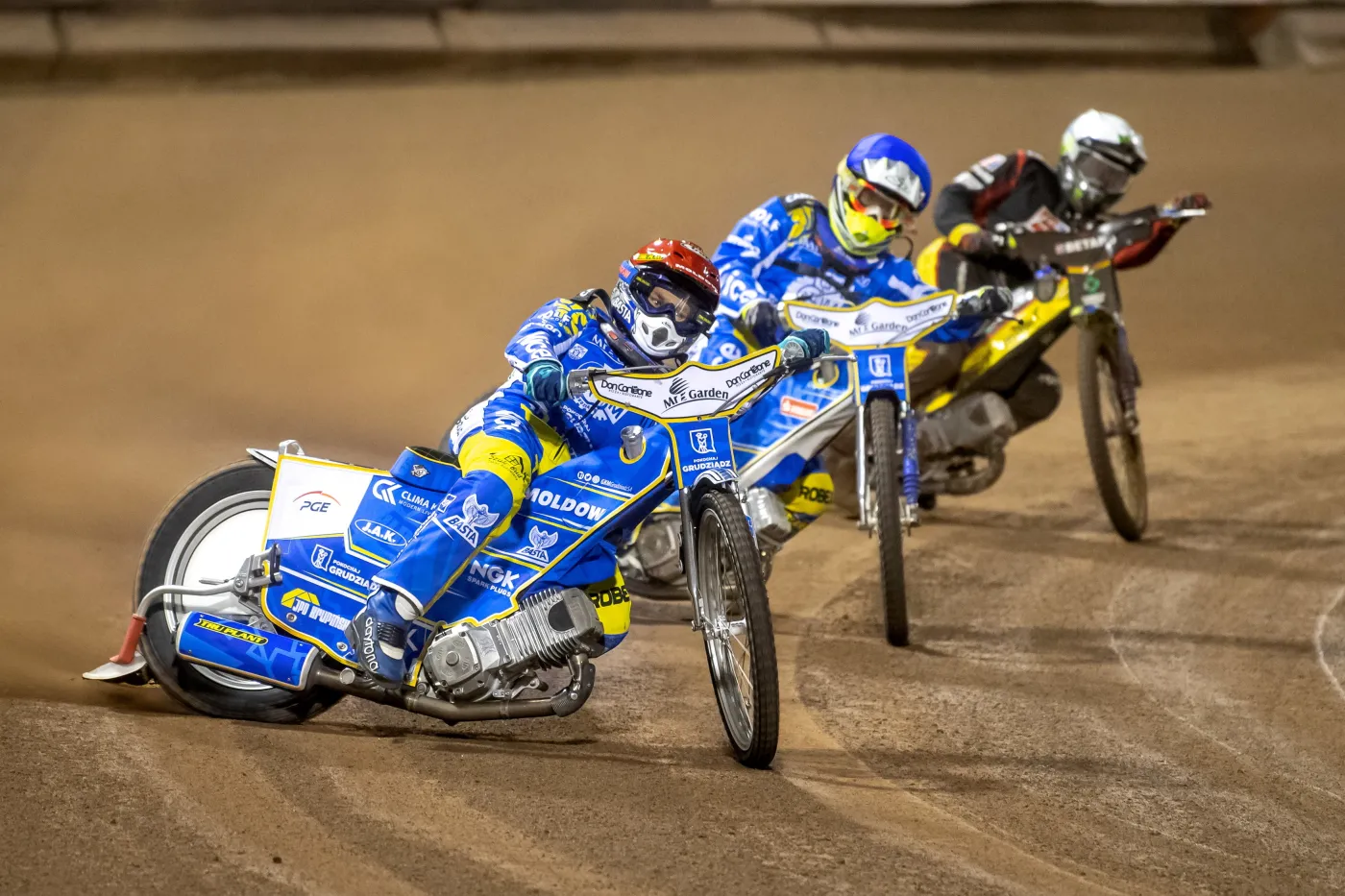 Nicki Pedersen (kask czerwony) i Kenneth Bjerre (niebieski) z MrGarden GKM Grudziądz oraz Chris Holder (biały) z Betardu Sparty Wrocław podczas meczu żużlowej Ekstraligi