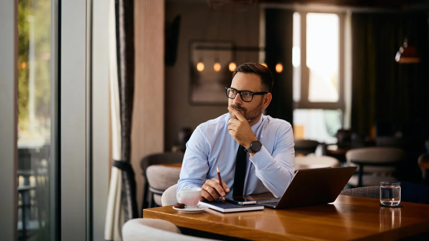 Smiling,Entrepreneur,Thinking,Of,Something,While,Working,On,A,Computer