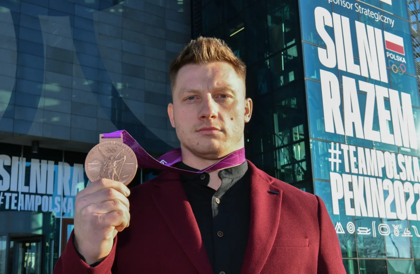 Sztangista Tomasz Zieliński pozuje do zdjęcia z brązowym medalem igrzysk olimpijskich w Londynie, który odebrał 21 bm. w siedzibie Polskiego Komitetu Olimpijskiego w Warszawie