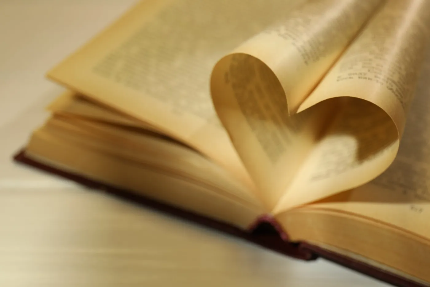 Love.,Open,Book,With,Pages,Folded,In,Heart,Shape,On
