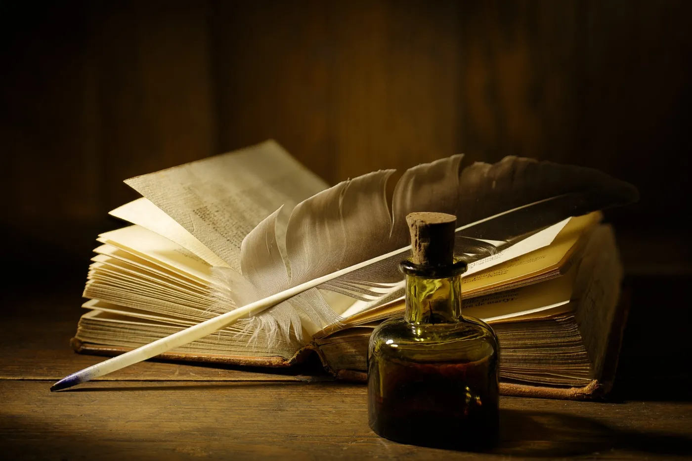 Antique,Feather,Quill,And,Inkwell,On,An,Open,,Aged,Book.