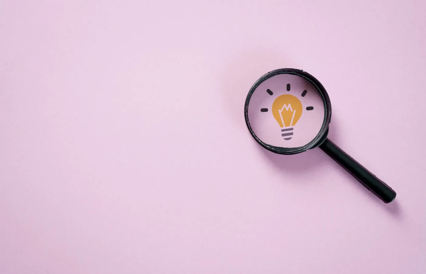 Magnifying,Glass,Revealing,Light,Bulb,Icon,On,Pink,Background.,Creative