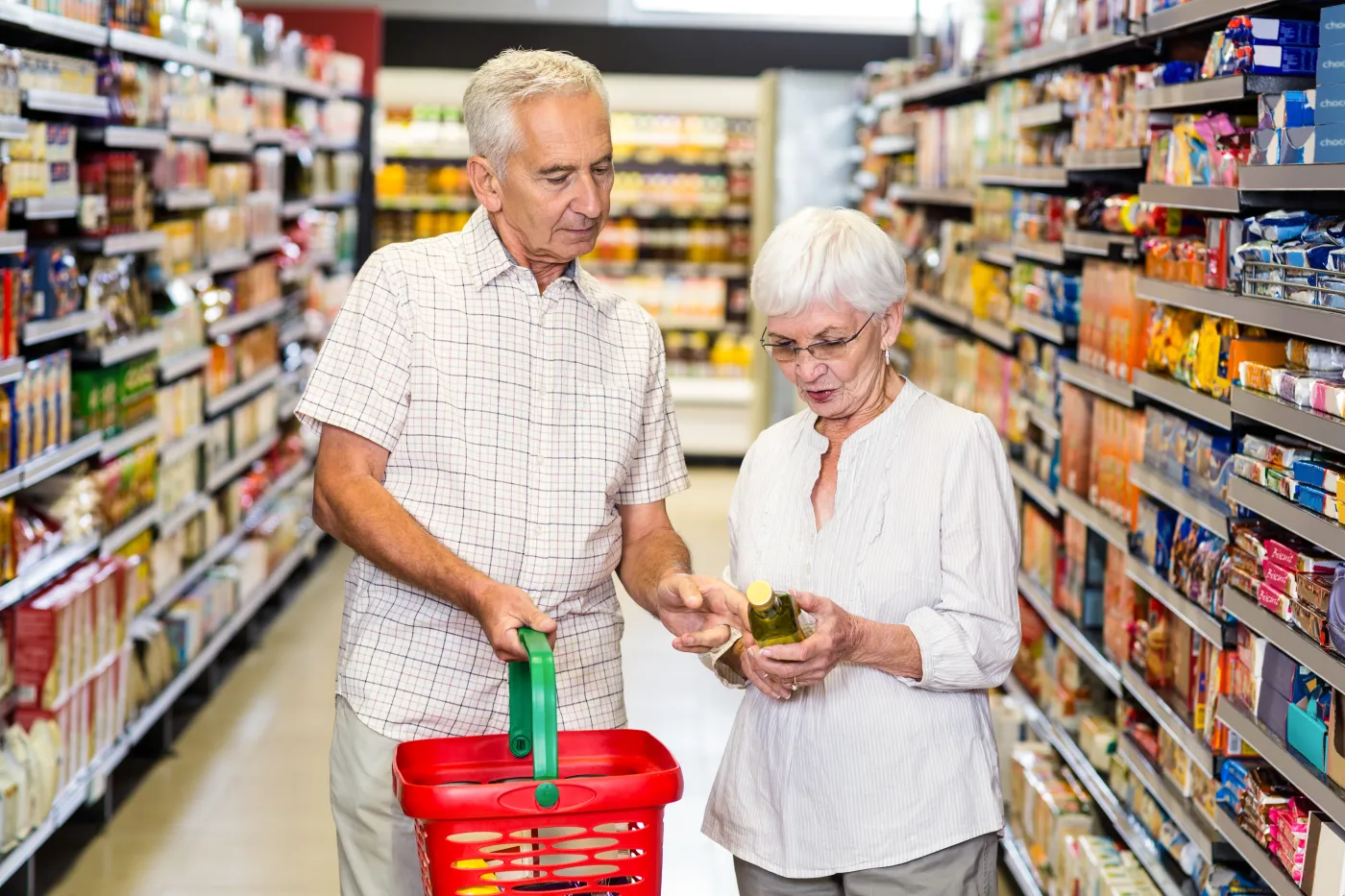 Senior,Couple,Holding,Oil,Bottle,At,The,Supermarket