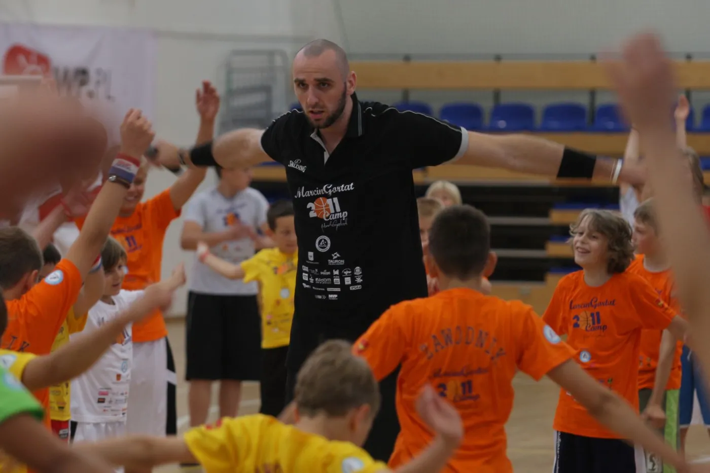 Marcin Gortat uczy grać w koszykówkę dzieci w Łodzi.