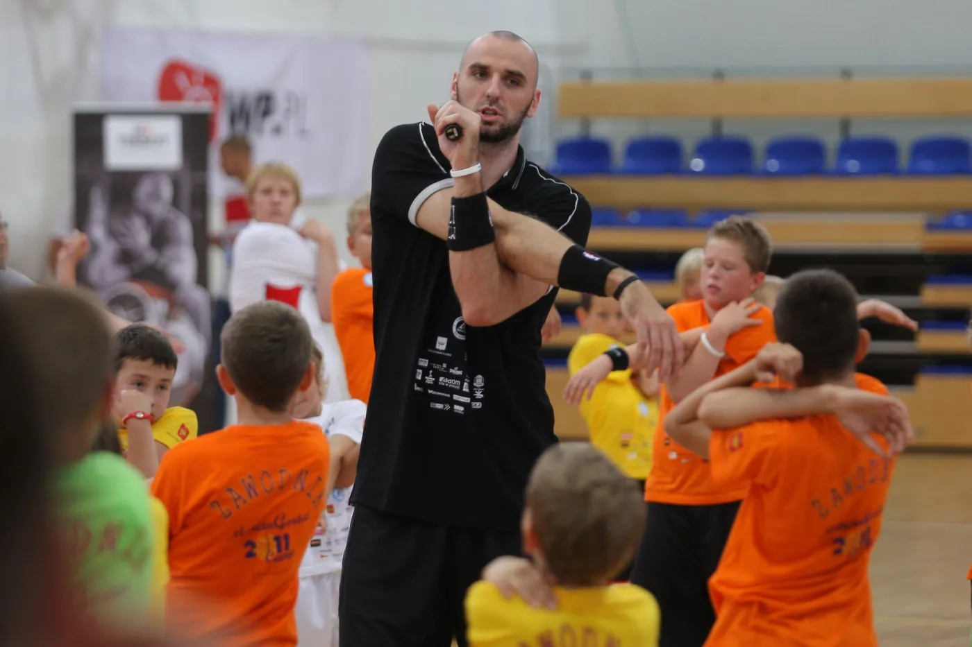 Marcin Gortat uczy grać w koszykówkę dzieci w Łodzi.