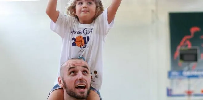 Marcin Gortat uczy grać w koszykówkę dzieci w Łodzi.