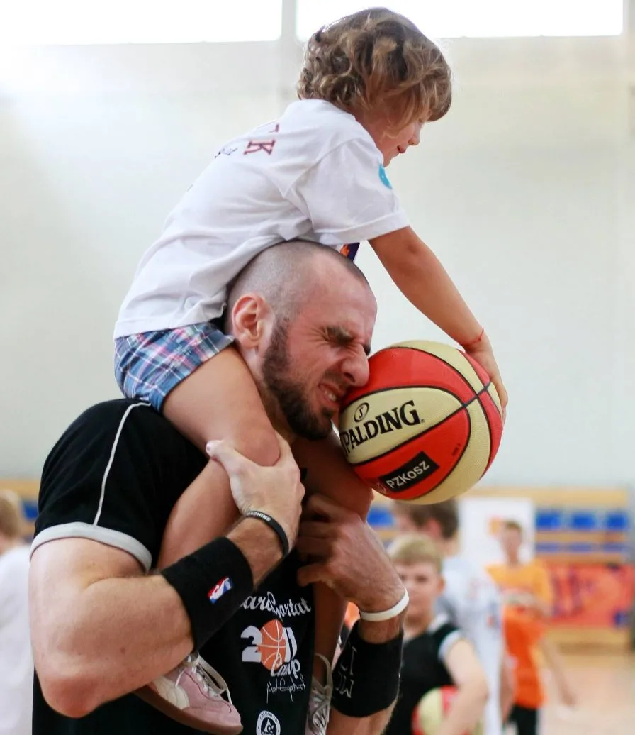 Marcin Gortat uczy grać w koszykówkę dzieci w Łodzi.