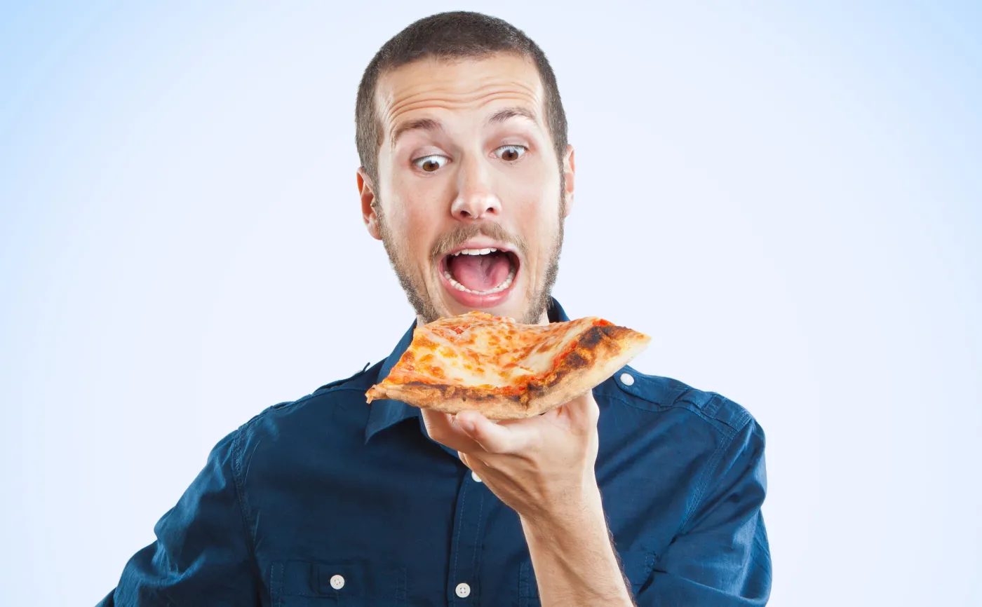 Głodny mężczyzna je pizzę