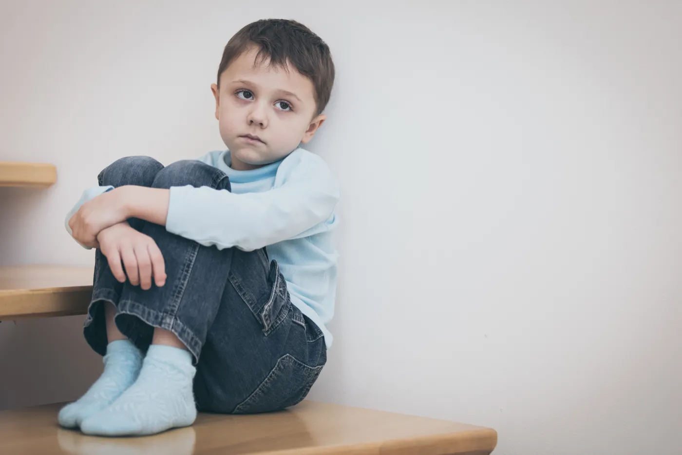One,Sad,Little,Boy,Sitting,On,The,Stairs,In,House