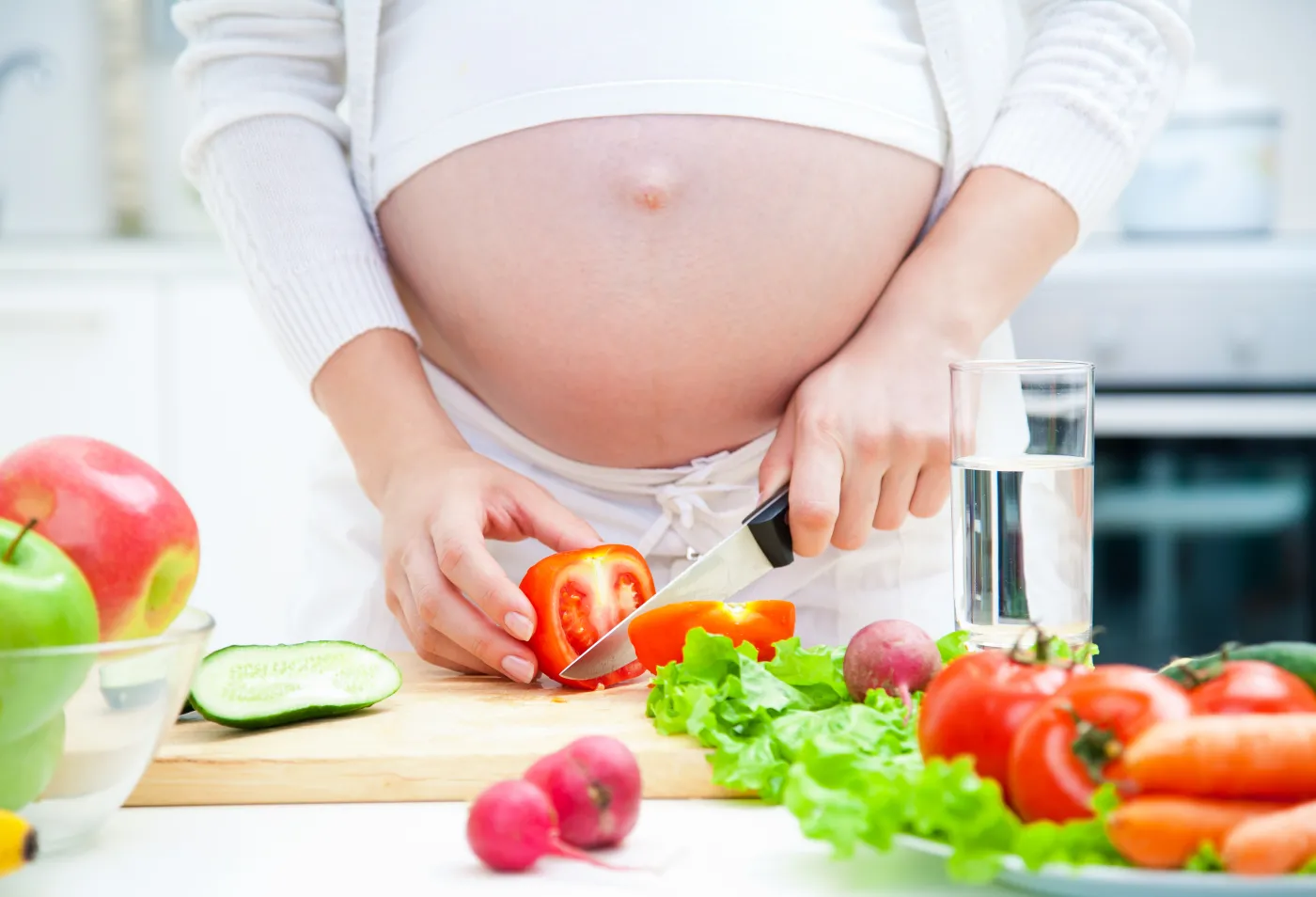 Pregnant,Woman,In,Kitchen,Making,Salad