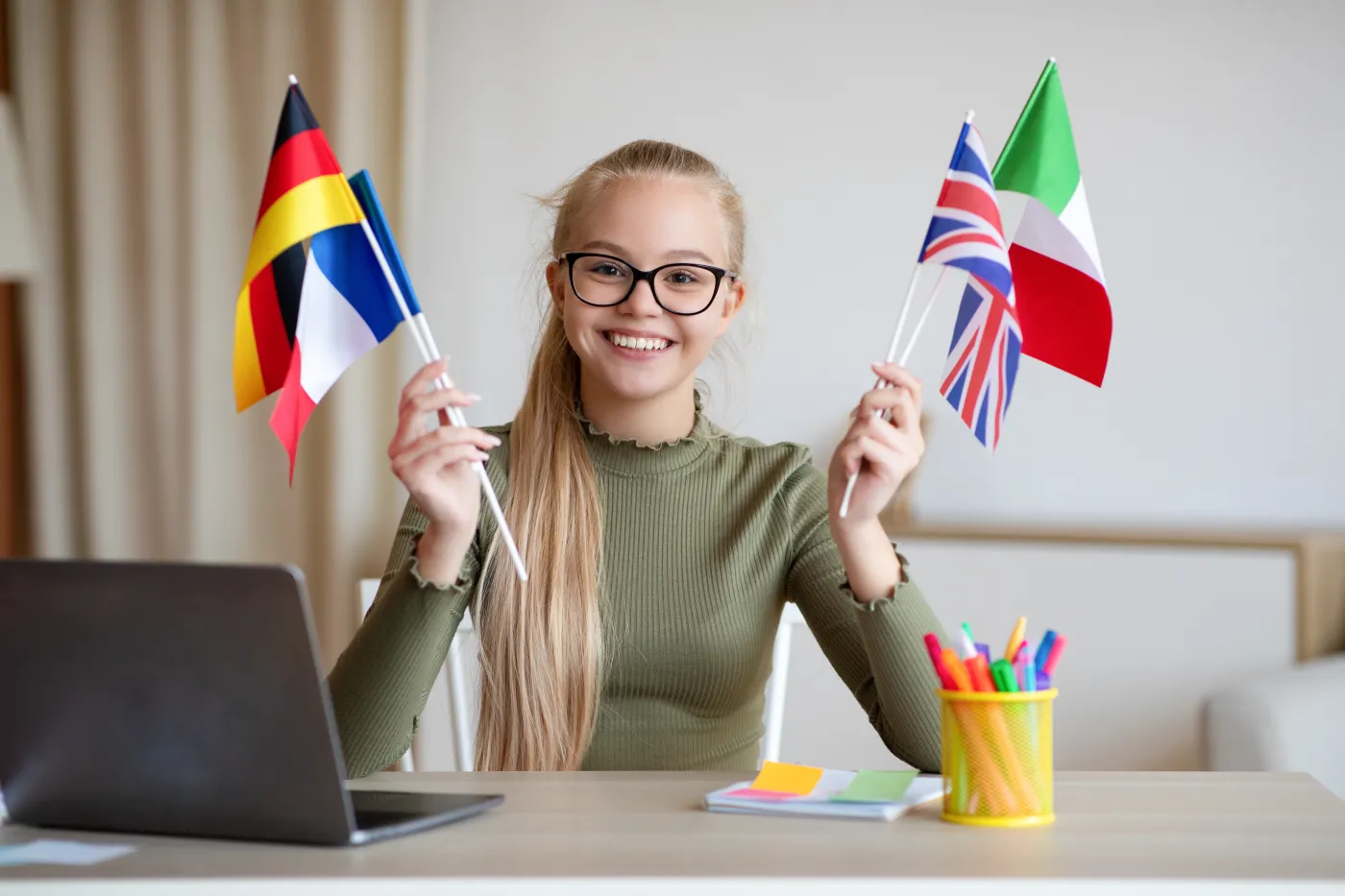Cheerful,Blonde,Teen,Girl,With,Glasses,Sitting,At,Workdesk,With