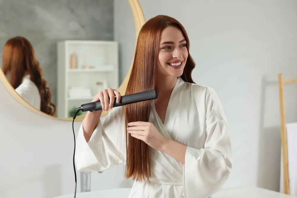 Beautiful,Woman,Using,Hair,Iron,In,Room