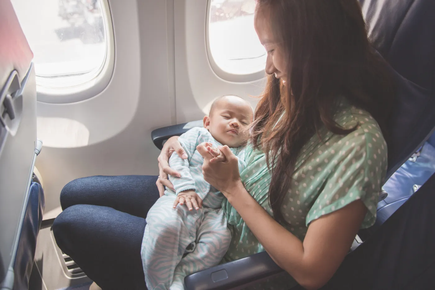 Happy,Mother,And,Baby,Sitting,Together,In,Airplane,Cabin,Near