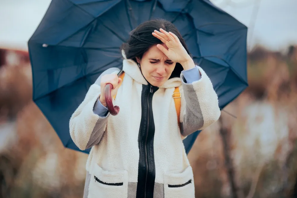 Woman,Holding,Her,Umbrella,Walking,Into,A,Windstorm.,Unhappy,Person