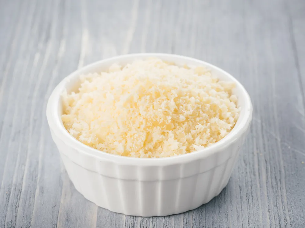 White,Ceramic,Bowl,With,Freshly,Grated,Parmesan,Cheese,On,Gray