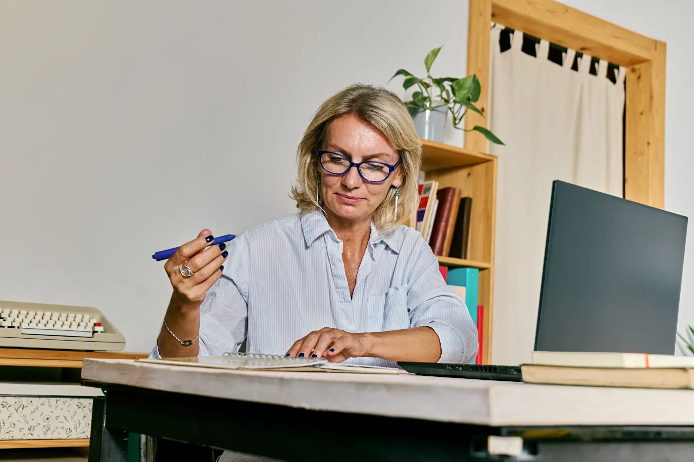 Thoughtful,Blond,Haired,Business,Woman,Making,Notes,In,Notebook,A