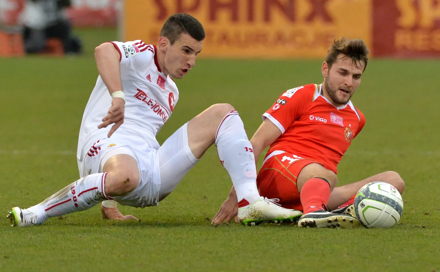 Zawodnik Widzewa Łódź Mateusz Cetnarski (P) walczy o piłkę z Gordanem Bunozą (L) z Wisły Kraków