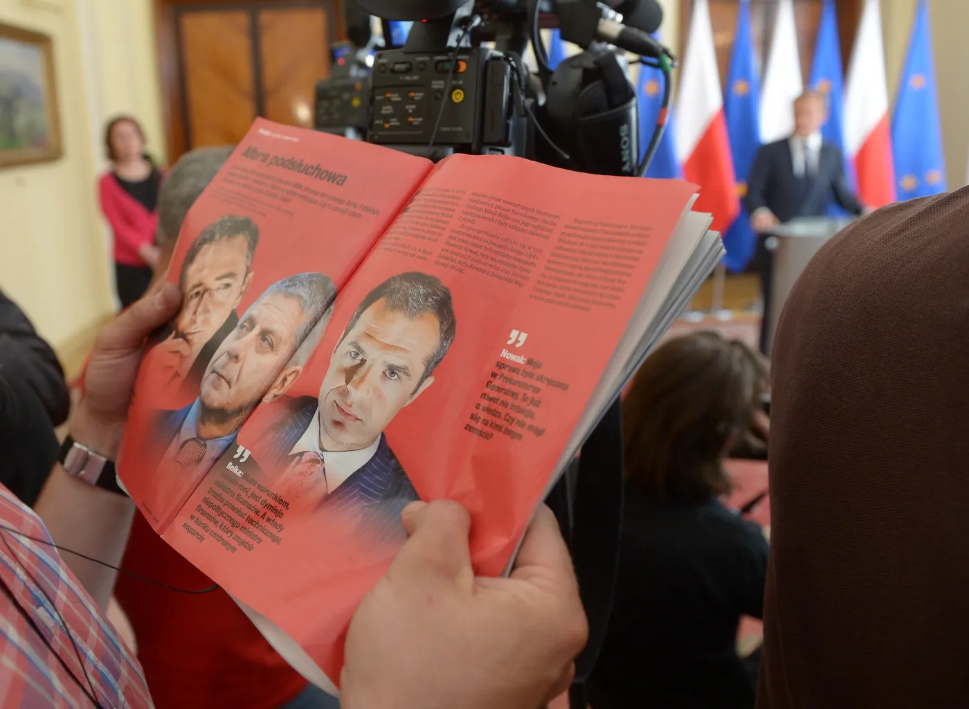 "Wprost" o aferze podsłuchowej. Dziennikarz przegląda tygodnik na konferencji premiera Donalda Tuska