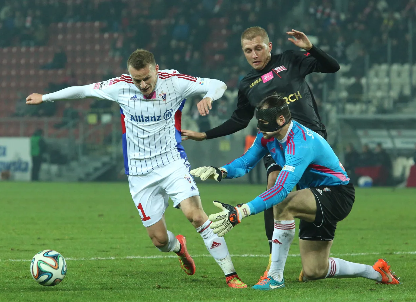 Zawodnik Górnika Zabrze Roman Gergel (L) wspiera swojego bramkarza Pavelsa Steinborsa (P) którego atakuje Deniss Rakels (C) z Cracovii