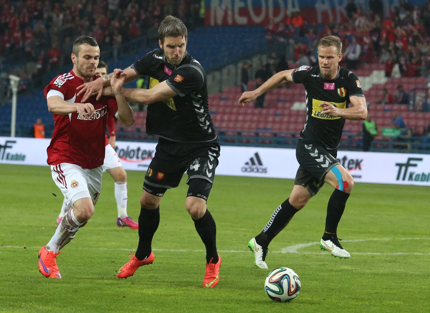 Paweł Brożek (L) z miejscowej Wisły oraz Piotr Malarczyk (C) i Radek Dejmek (P) z Korony Kielce w meczu T-Mobile Ekstraklasy w Krakowie
