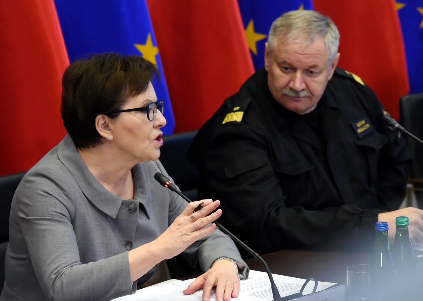 Premier Ewa Kopacz i zastępca Komendanta Głównego Państwowej Straży Pożarnej Gustaw Mikołajczyk podczas spotkania z przedstawicielami Rządowego Zespołu Zarządzania Kryzysowego
