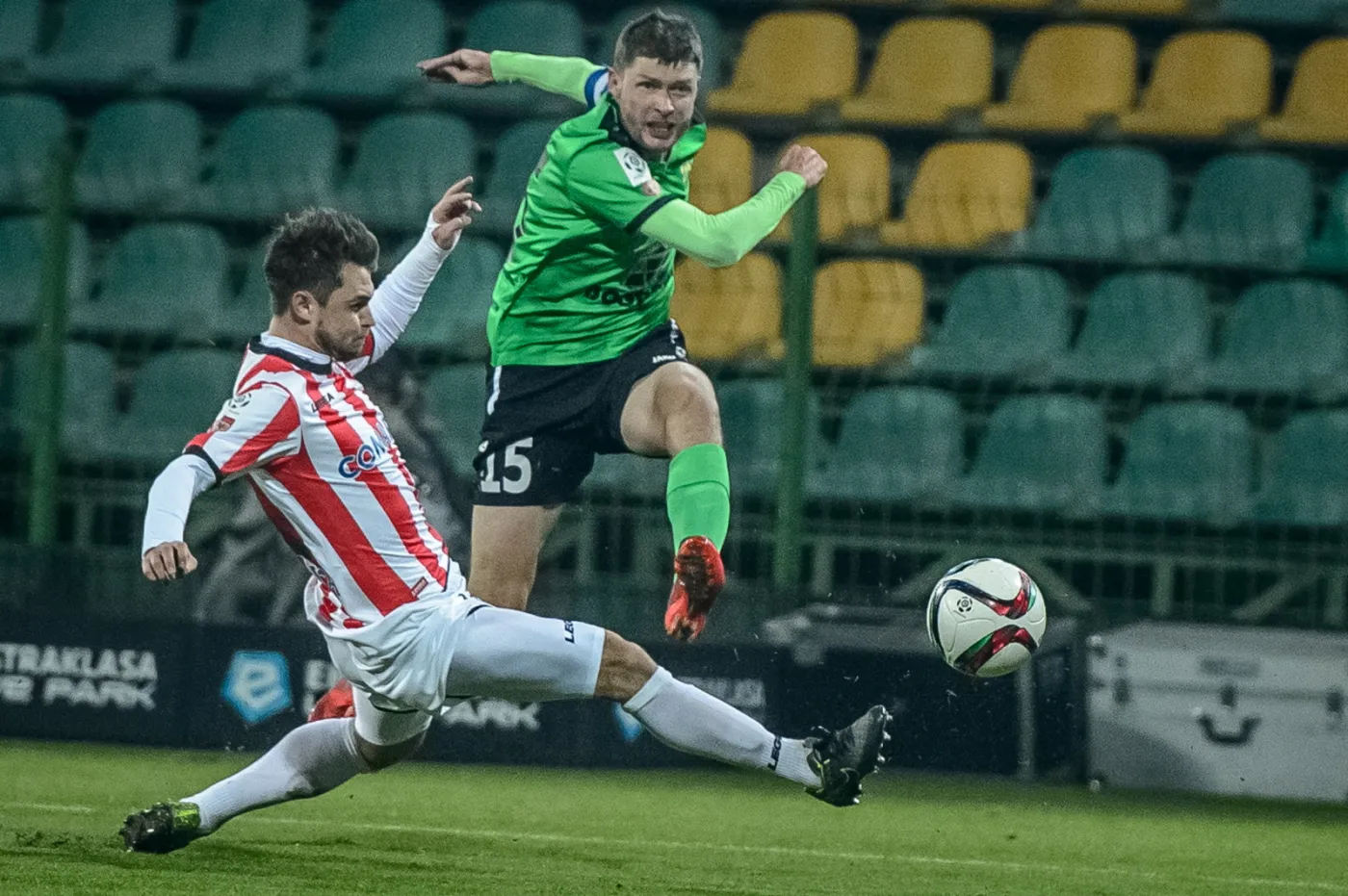 Zawodnik KGHM Zagłębie Lubin Grzegorz Bonin (P) z walczy o piłkę z Hubertem Wołąkiewiczem (L) z Cracovii 