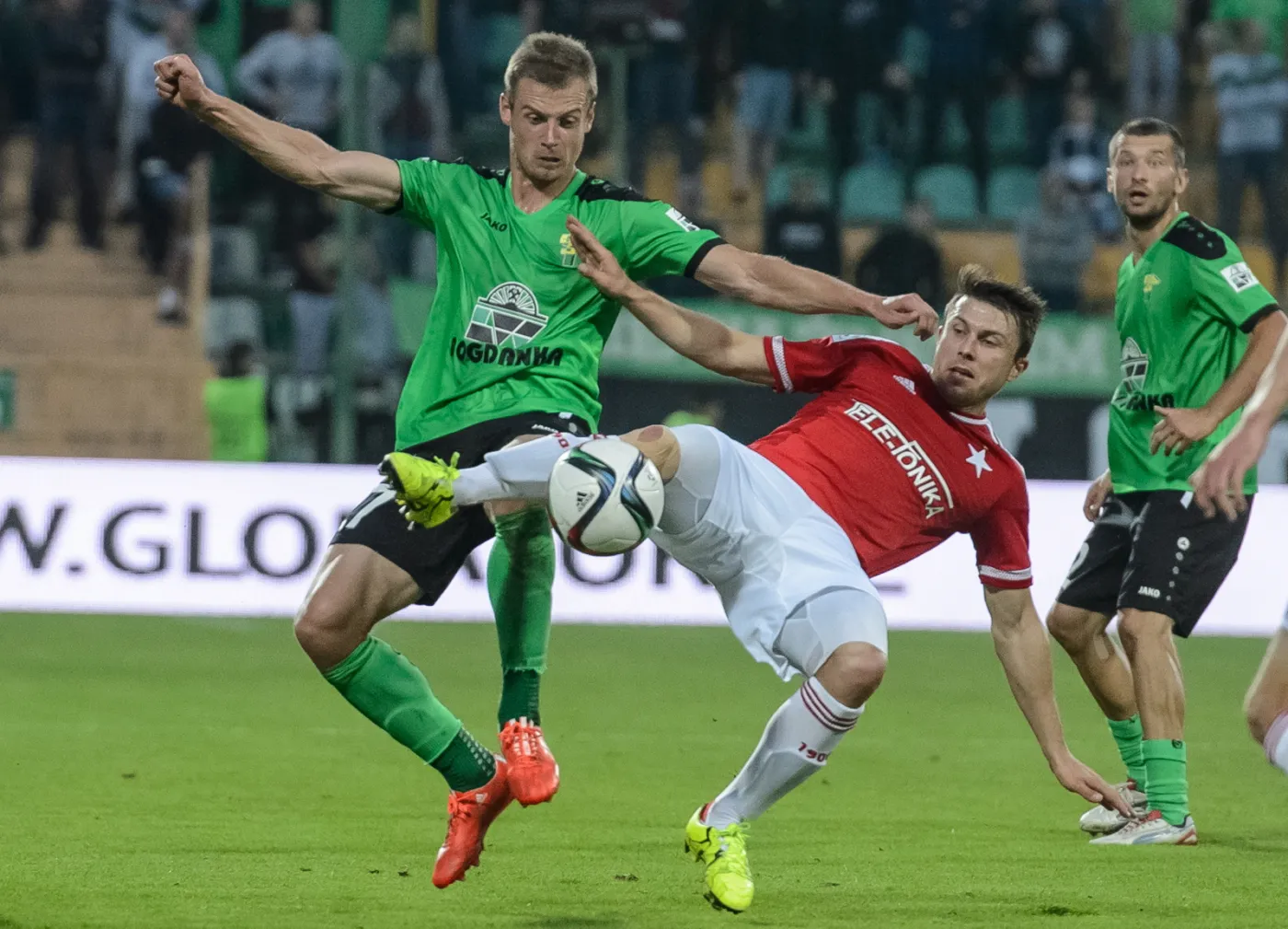 Adrian Basta (L) z miejscowego Górnika i Łukasz Burliga (C) z Wisły Kraków w meczu T-Mobile Ekstraklasy, rozegranym w Łęcznej