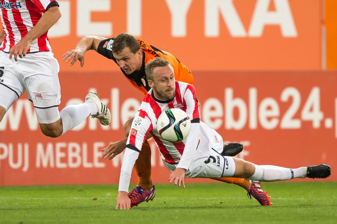 Maciej Dąbrowski (wyżej) z KGHM Zagłębia Lubin walczy o piłkę z Dariuszem Zjawińskim z Cracovii w meczu T-Mobile Ekstraklasy