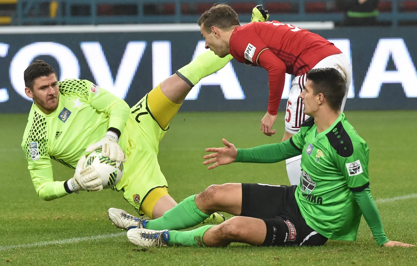 Zawodnicy Wisły Kraków Łukasz Załuska (L) i Boban Jovic (2P) oraz Piotr Grzelczak (P) z Górnika Łęczna