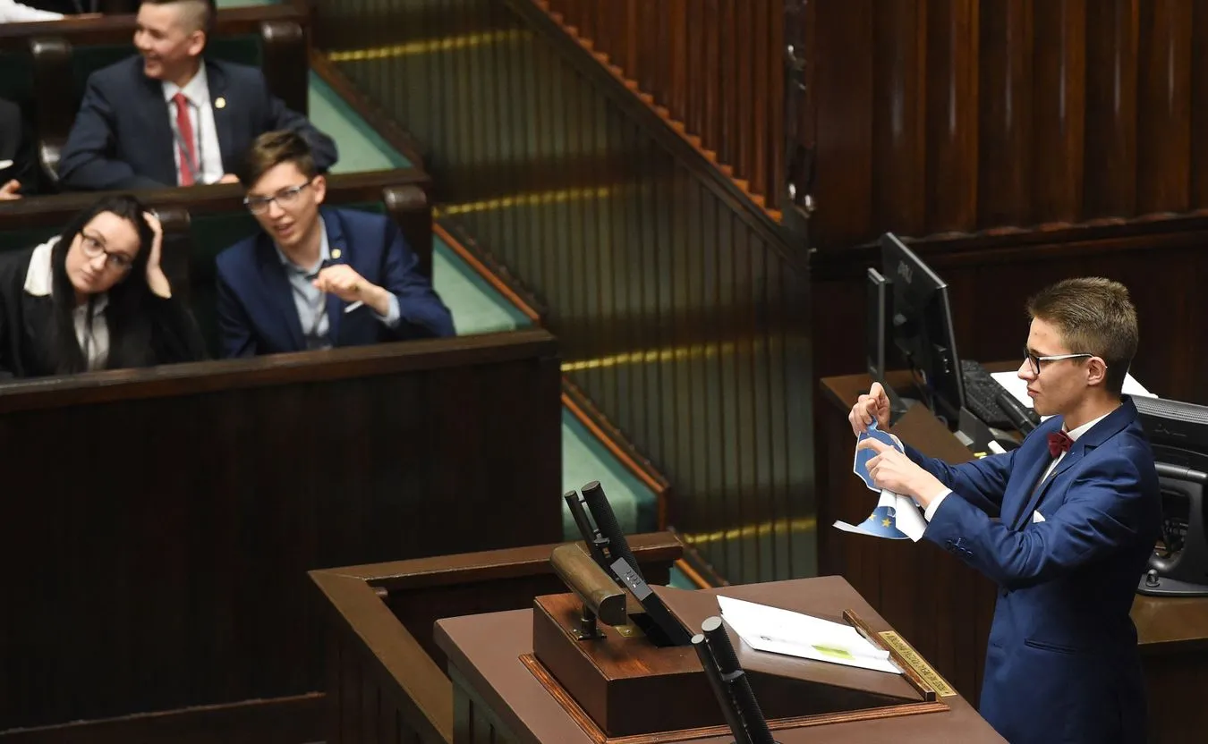Młody poseł Michał Cywiński drze kartkę z flagą Unii Europejskiej
